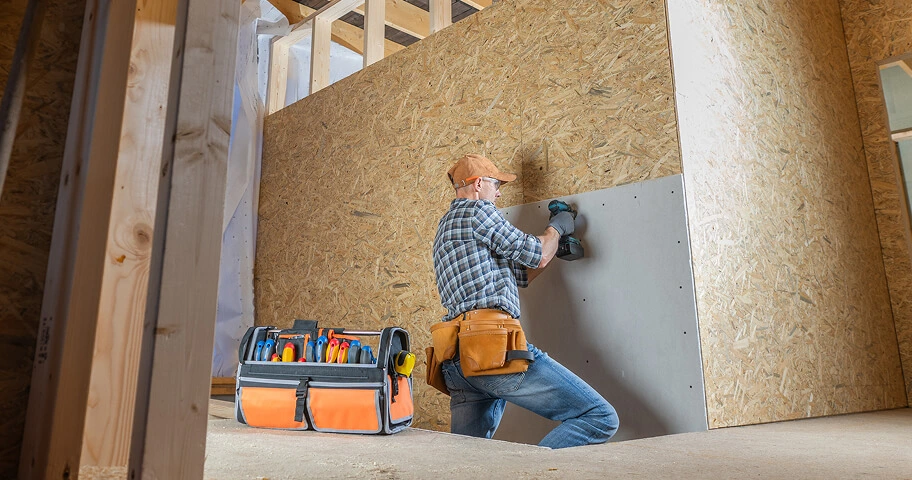 Worker renovating wooden wall