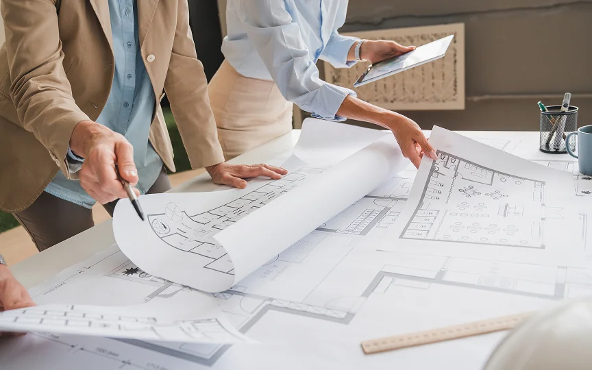 collaborative team analyzing architectural blueprints in professional office