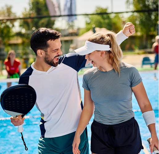 cheerful athletic couple celebrating during padel