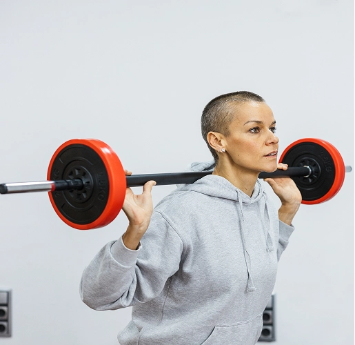 determined sportswoman performing weighted squats