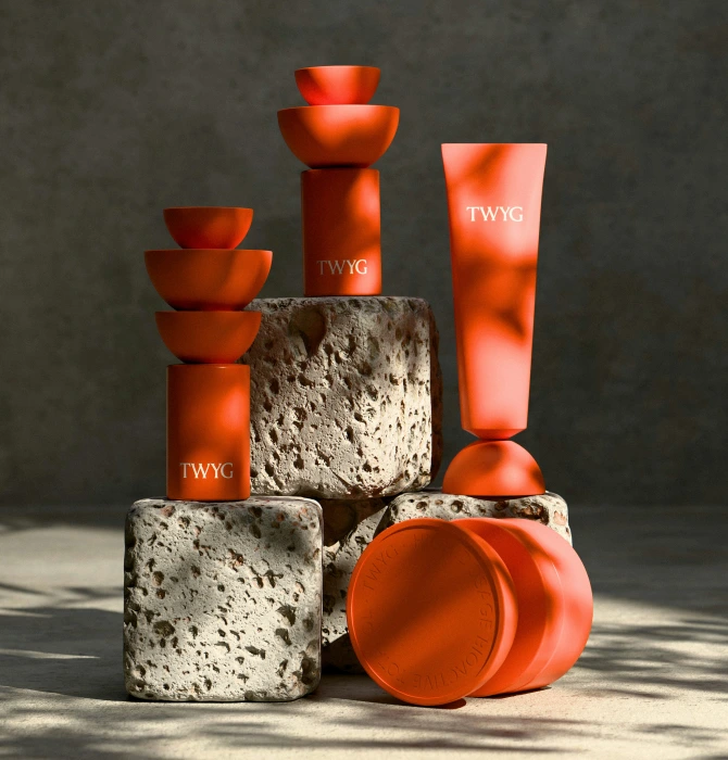 Orange cosmetic containers displayed on stone blocks